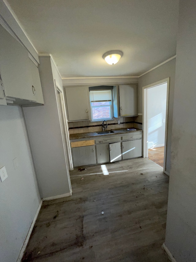 11336 Minock St, Detroit, MI 48228 - kitchen featuring a sink, wood finished floors, white cabinets, ornamental molding, and baseboards