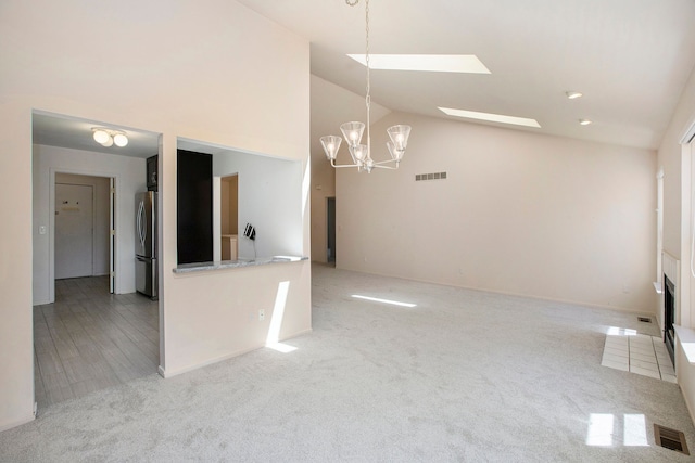 unfurnished living room with a chandelier, carpet, and high vaulted ceiling