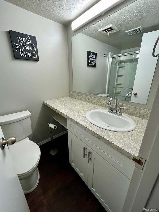 6210 Tennis Ct Unit D-11, Bay City, MI 48706 - full bath featuring a textured ceiling, toilet, vanity, a shower with shower door, and wood finished floors