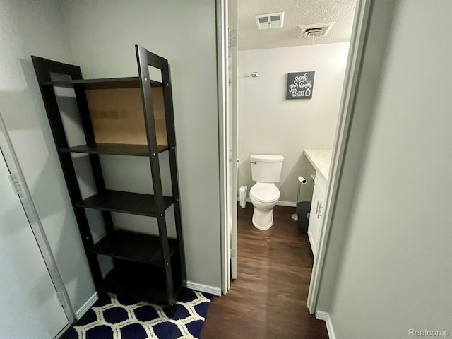 6210 Tennis Ct Unit D-11, Bay City, MI 48706 - bathroom with toilet, wood finished floors, baseboards, vanity, and a textured ceiling