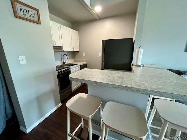 6210 Tennis Ct Unit D-11, Bay City, MI 48706 - kitchen featuring stainless steel appliances, white cabinetry, a kitchen bar, and light countertops