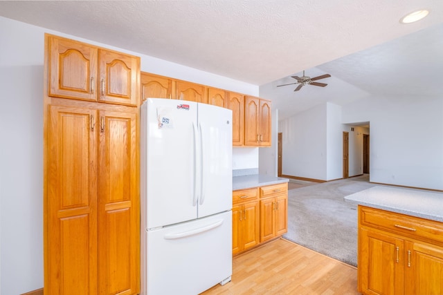 11021 Heather Ln, Canadian Lakes, MI 49346 - kitchen with freestanding refrigerator, a ceiling fan, light countertops, vaulted ceiling, and light wood finished floors