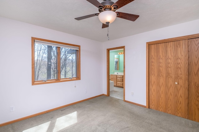 11021 Heather Ln, Canadian Lakes, MI 49346 - unfurnished bedroom featuring light carpet, baseboards, ensuite bath, a closet, and a ceiling fan