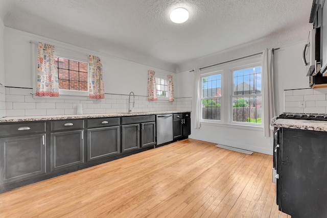 18600 Monica St, Detroit, MI 48221 - kitchen with stainless steel appliances, decorative backsplash, a textured ceiling, light wood-type flooring, and a sink