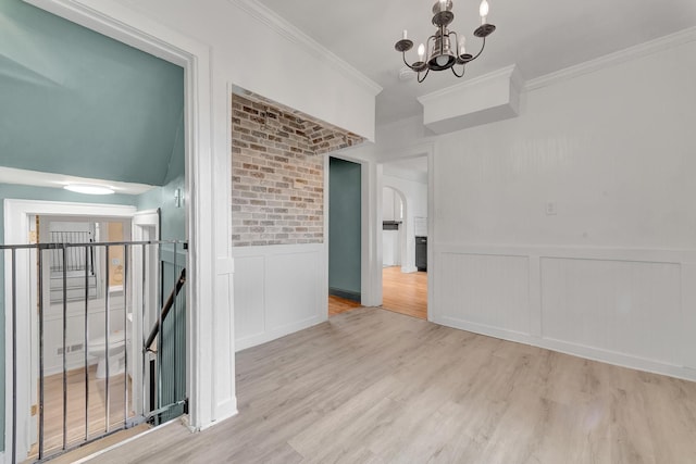 18600 Monica St, Detroit, MI 48221 - empty room featuring a chandelier, wood finished floors, ornamental molding, a decorative wall, and arched walkways