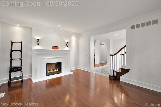 222 Arlington St, Birmingham, MI 48009 - unfurnished living room with wood-type flooring, stairs, a glass covered fireplace, recessed lighting, and crown molding