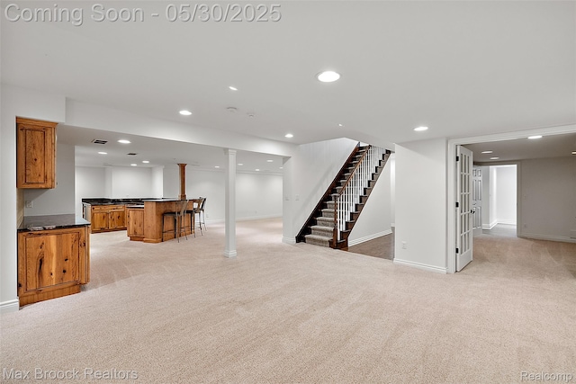 222 Arlington St, Birmingham, MI 48009 - unfurnished living room featuring bar with sink, light colored carpet, stairs, baseboards, and recessed lighting