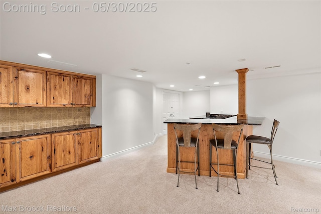 222 Arlington St, Birmingham, MI 48009 - kitchen featuring recessed lighting, brown cabinets, baseboards, light colored carpet, and a kitchen breakfast bar