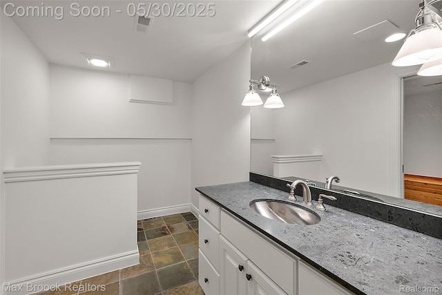 222 Arlington St, Birmingham, MI 48009 - bathroom featuring vanity, stone finish floors, and baseboards