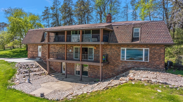 5060 Pratt Rd, Metamora, MI 48455 - back of property with a chimney, brick siding, a patio area, a balcony, and cooling unit