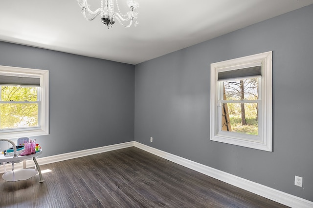 5060 Pratt Rd, Metamora, MI 48455 - unfurnished room with a chandelier, dark wood-style floors, and baseboards