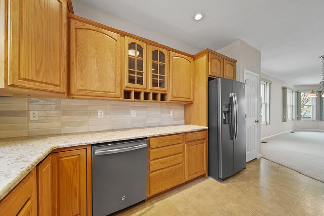 3605 Terrace Hills Ln, Jackson, MI 49203 - kitchen with stainless steel appliances, glass insert cabinets, light stone counters, and decorative backsplash