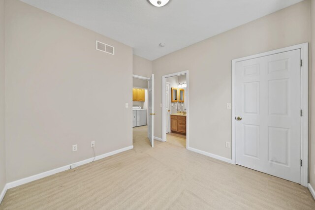 3605 Terrace Hills Ln, Jackson, MI 49203 - unfurnished bedroom with light carpet, baseboards, washer / clothes dryer, and ensuite bath