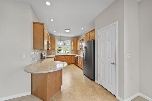 3605 Terrace Hills Ln, Jackson, MI 49203 - kitchen featuring appliances with stainless steel finishes, a peninsula, a sink, backsplash, and baseboards