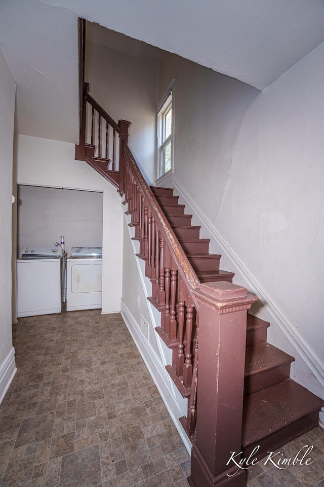 stairs featuring separate washer and dryer, baseboards, and stone finish floors