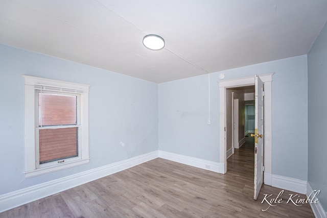 unfurnished room featuring baseboards and wood finished floors