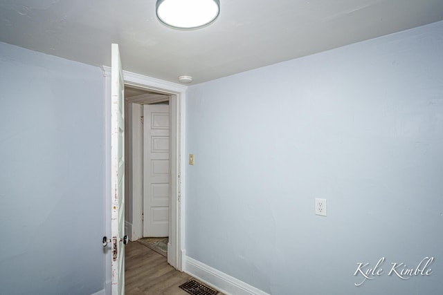empty room featuring light wood-style floors, baseboards, and a smoke detector
