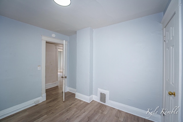 spare room with wood finished floors and baseboards