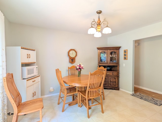 dining room with a chandelier and baseboards
