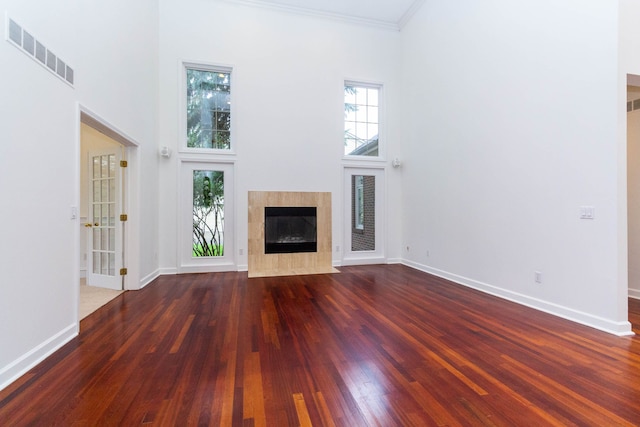 685 Dornoch Dr, Ann Arbor, MI 48103 - unfurnished living room featuring a high ceiling, wood finished floors, a tiled fireplace, healthy amount of natural light, and baseboards