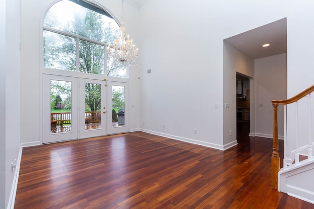 685 Dornoch Dr, Ann Arbor, MI 48103 - unfurnished living room with a towering ceiling, stairway, wood finished floors, baseboards, and a chandelier