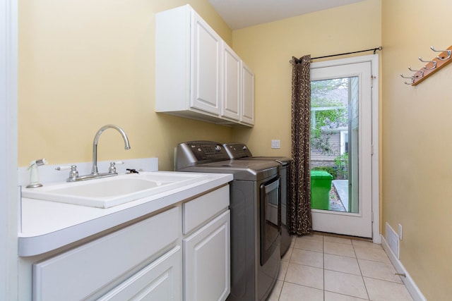 685 Dornoch Dr, Ann Arbor, MI 48103 - washroom with cabinet space, washing machine and dryer, light tile patterned flooring, and baseboards