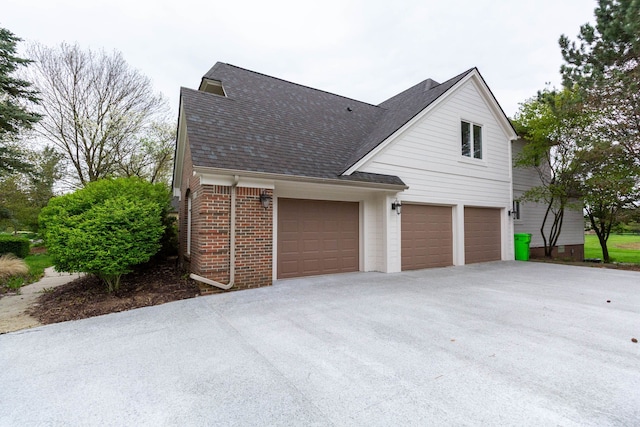 685 Dornoch Dr, Ann Arbor, MI 48103 - view of side of property with roof with shingles, brick siding, a garage, and driveway