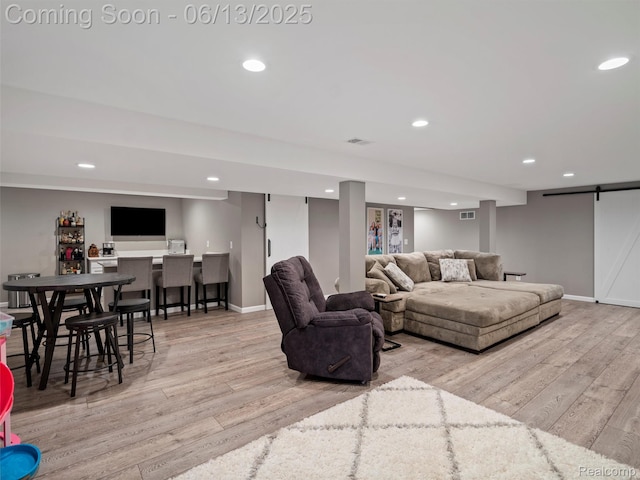 45877 Andrew Dr, Macomb, MI 48044 - living room with a barn door, wood finished floors, bar, and recessed lighting