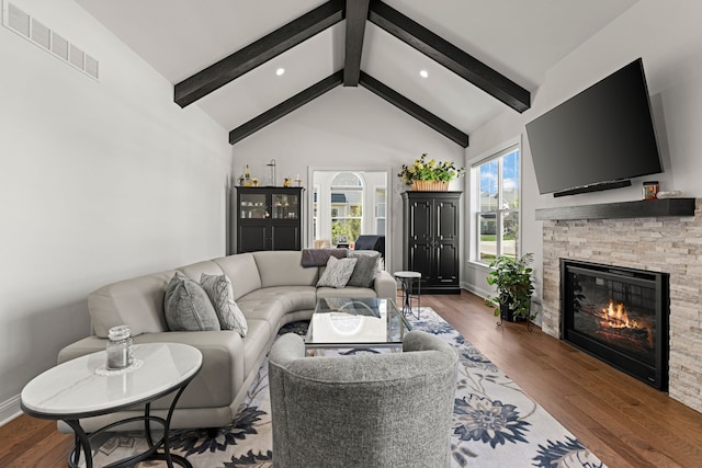 living area featuring beamed ceiling, a fireplace, wood finished floors, baseboards, and recessed lighting