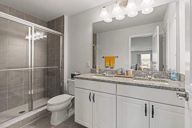 full bathroom featuring toilet, a stall shower, double vanity, and tile patterned flooring