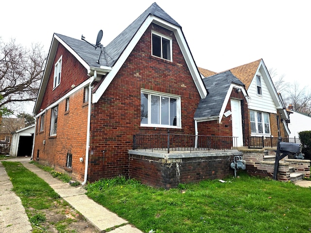 19183 Yonka St, Detroit, MI 48234 - view of side of property with brick siding, an outbuilding, a lawn, a garage, and a shingled roof