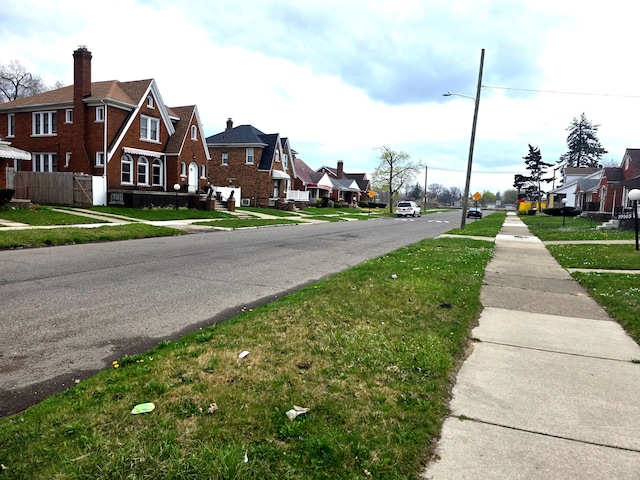 19183 Yonka St, Detroit, MI 48234 - view of asphalt road with sidewalks, a residential view, street lighting, and traffic signs