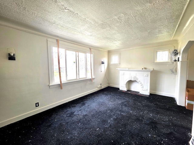 19183 Yonka St, Detroit, MI 48234 - unfurnished living room with a textured ceiling, baseboards, dark colored carpet, a fireplace with flush hearth, and crown molding