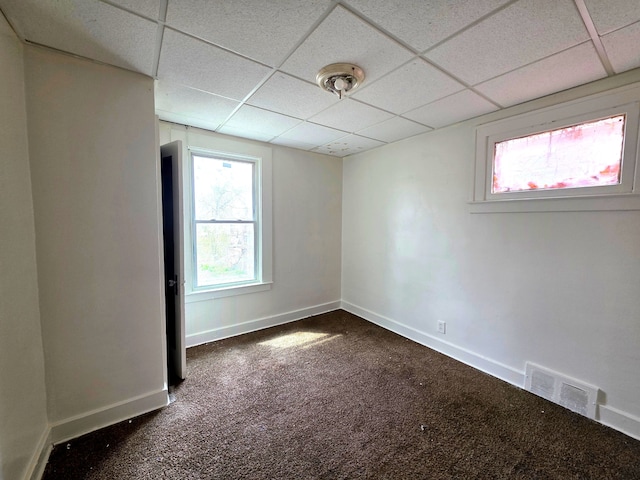 19183 Yonka St, Detroit, MI 48234 - spare room with dark colored carpet, a paneled ceiling, and baseboards