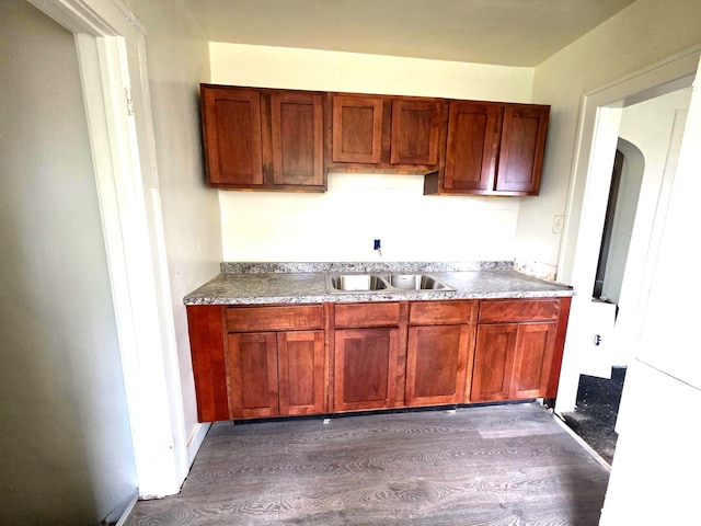 19183 Yonka St, Detroit, MI 48234 - kitchen featuring dark wood-style floors, a sink, and arched walkways