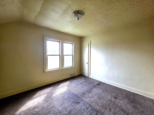 19183 Yonka St, Detroit, MI 48234 - spare room featuring dark colored carpet, baseboards, a textured ceiling, and lofted ceiling