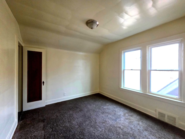 19183 Yonka St, Detroit, MI 48234 - unfurnished room featuring lofted ceiling, dark colored carpet, and baseboards