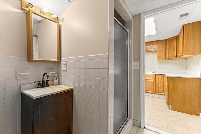 6809 Kingsley St, Dearborn, MI 48126 - bathroom with a shower stall, tile walls, tile patterned flooring, wainscoting, and vanity