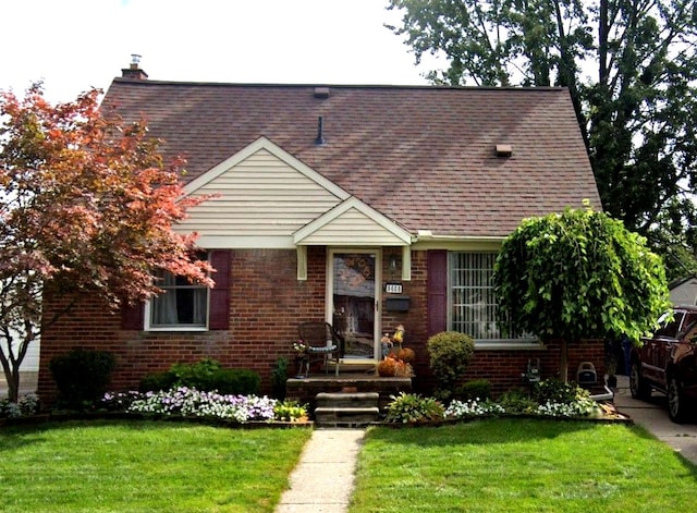 9608 Mercedes, Redford, MI 48239 - cape cod house featuring brick siding, a front yard, a shingled roof, and a chimney
