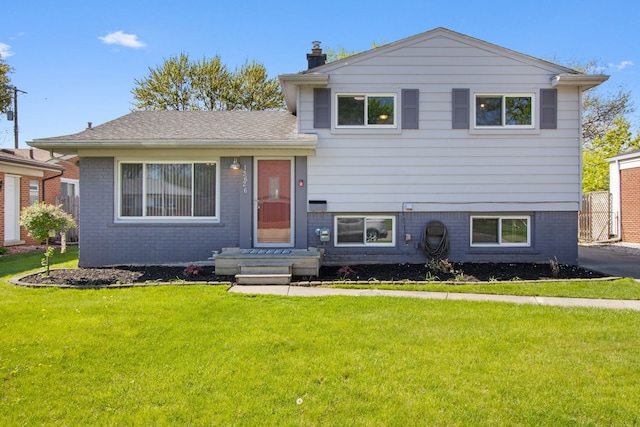 13626 Leisure Dr, Warren, MI 48088 - tri-level home with a front yard, brick siding, and a chimney
