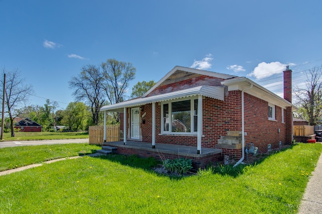 11580 Findlay St, Detroit, MI 48205 - view of front of property with a front yard, brick siding, a chimney, and a porch