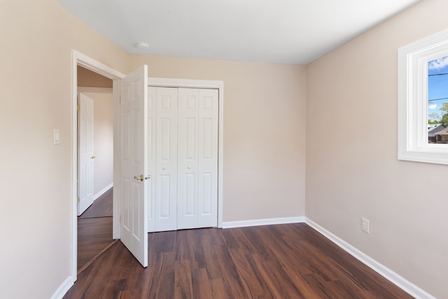 11580 Findlay St, Detroit, MI 48205 - unfurnished bedroom with dark wood finished floors, baseboards, and a closet