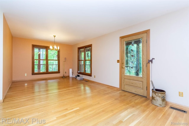3168 Farmbrook Ln, Metamora, MI 48455 - foyer with a chandelier, light wood-style floors, and baseboards