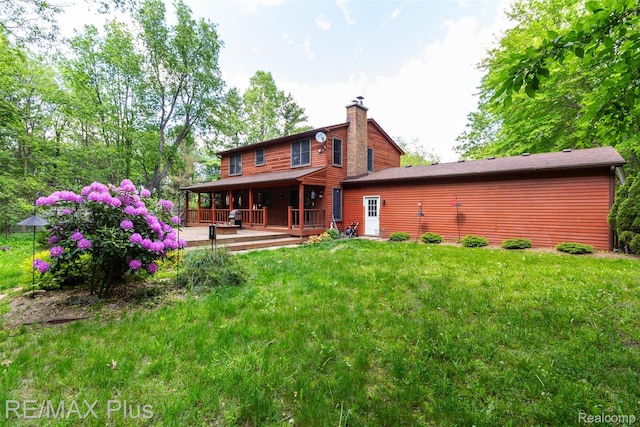 3168 Farmbrook Ln, Metamora, MI 48455 - back of property with a chimney, a lawn, and covered porch