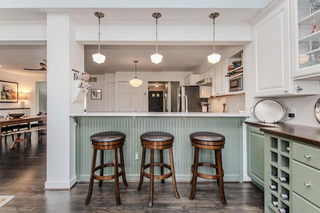 2142 Spring Ridge Dr, Ann Arbor, MI 48103 - kitchen featuring green cabinetry, stainless steel appliances, white cabinetry, a breakfast bar area, and dark wood-style floors