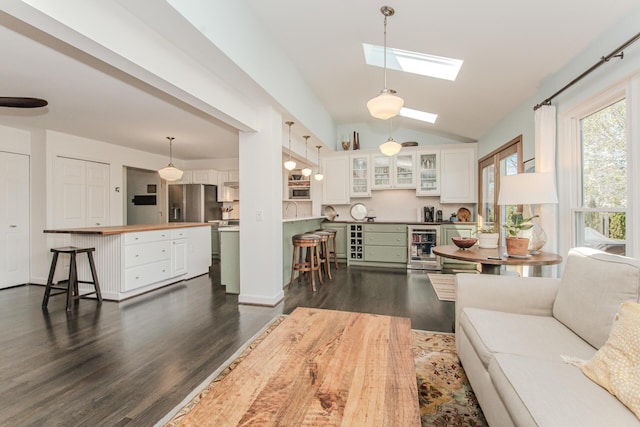 2142 Spring Ridge Dr, Ann Arbor, MI 48103 - living area featuring vaulted ceiling, dark wood-style floors, wine cooler, and a skylight