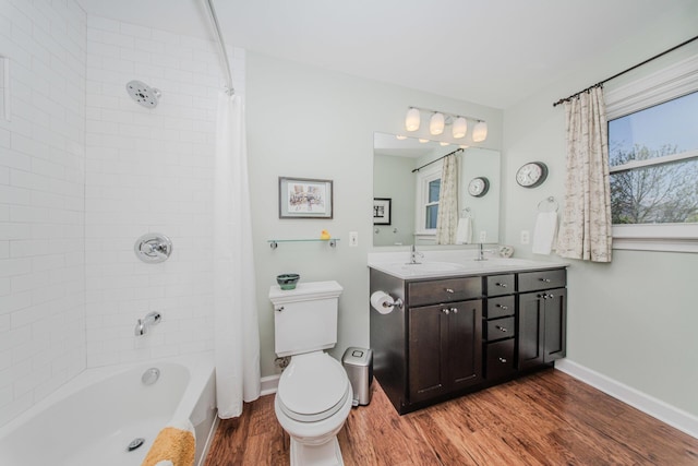 2142 Spring Ridge Dr, Ann Arbor, MI 48103 - bathroom with wood finished floors, toilet, shower / bath combo with shower curtain, double vanity, and baseboards