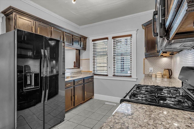 kitchen featuring black fridge with ice dispenser, gas stove, light tile patterned floors, backsplash, and crown molding