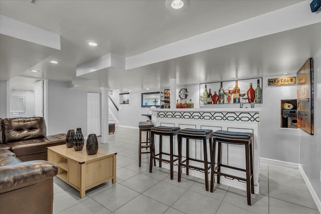 living room with a dry bar, light tile patterned floors, baseboards, stairway, and recessed lighting