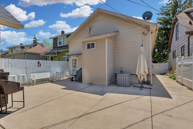 rear view of house featuring cooling unit, a patio, and fence